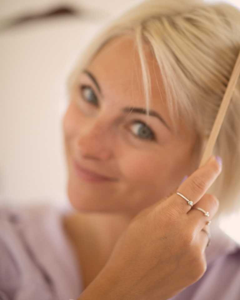 Image d’une femme coiffant ses cheveux blonds et courts