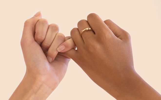 Image of two friends making a pinky promise 